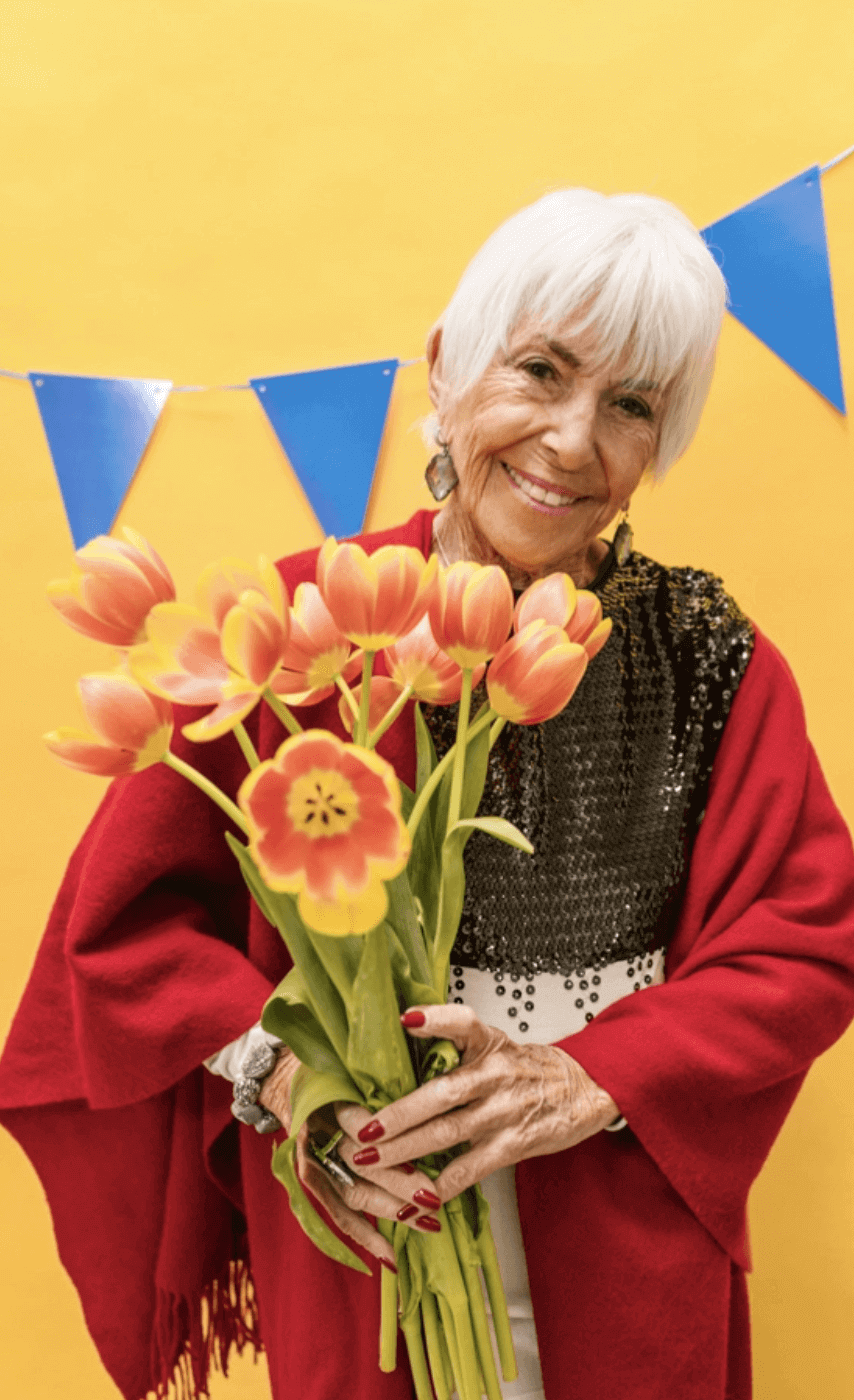 Happy elderly lady holding flowers