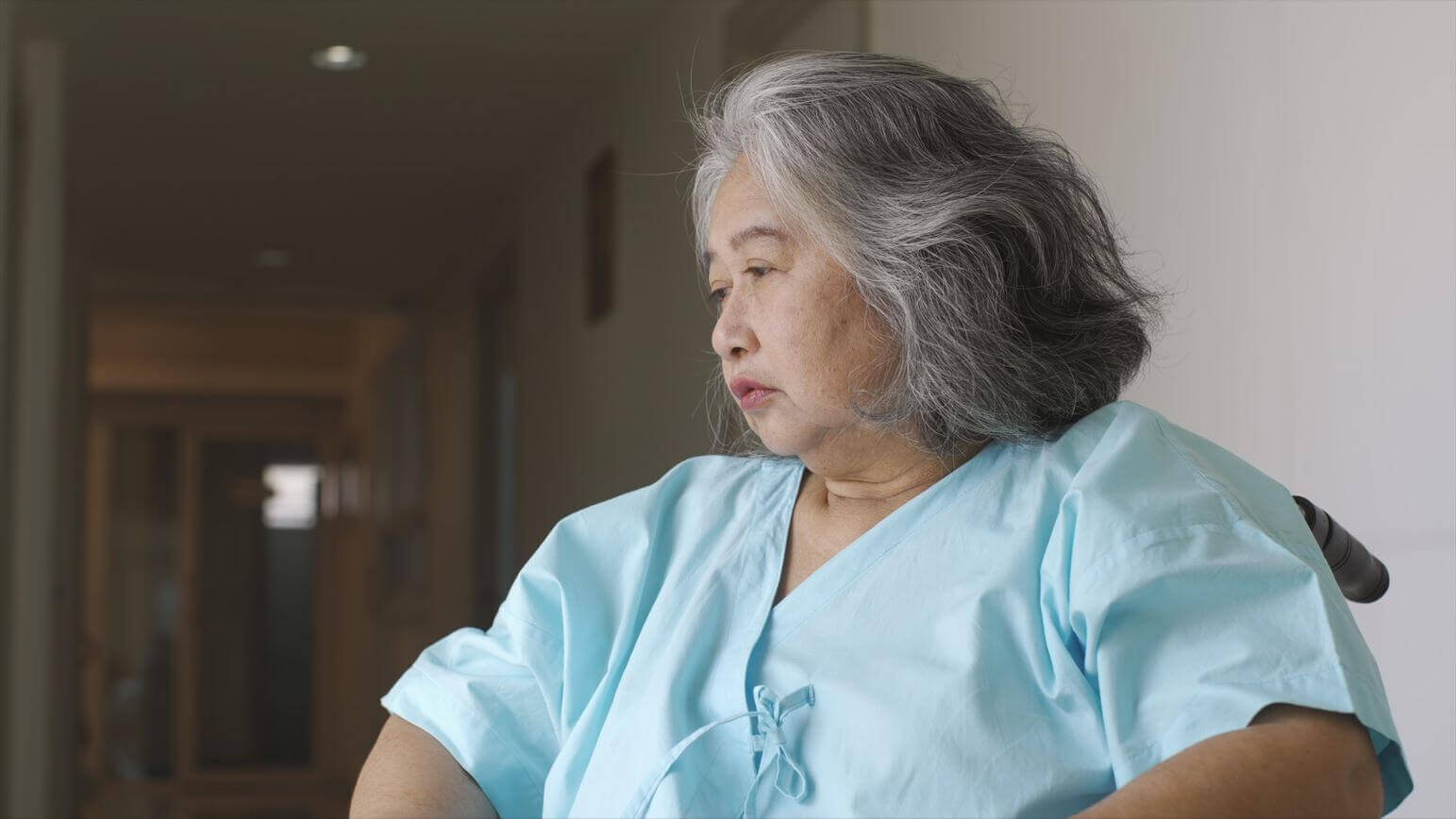 Sad lady in wheelchair in nursing home