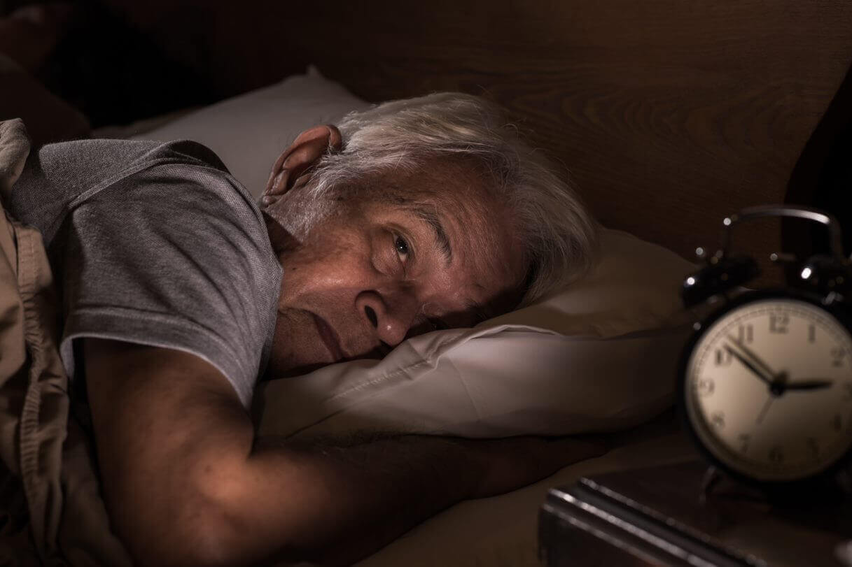 Sad man in bed in nursing home