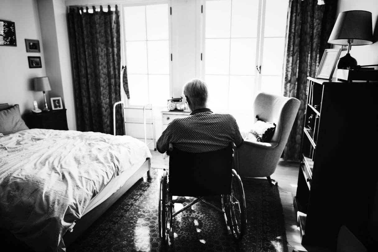 Sad man in wheelchair in nursing home